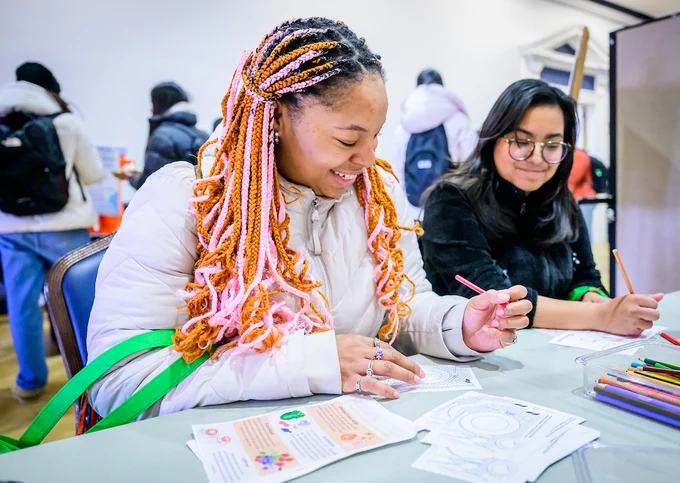two women smiling while working at a table