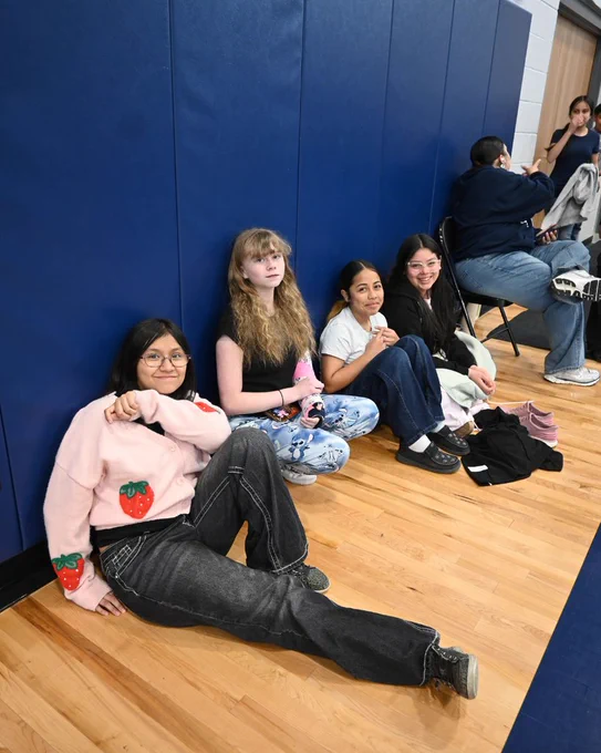 students sit along wall