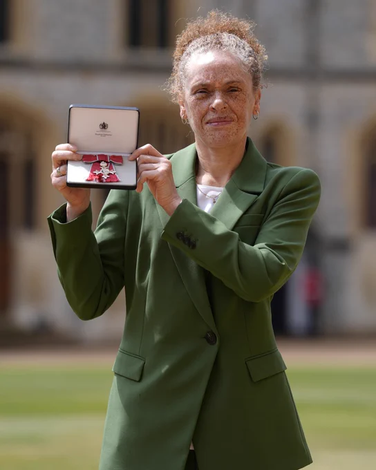 Kerry Davis holding her MBE outside Windsor Castle. 