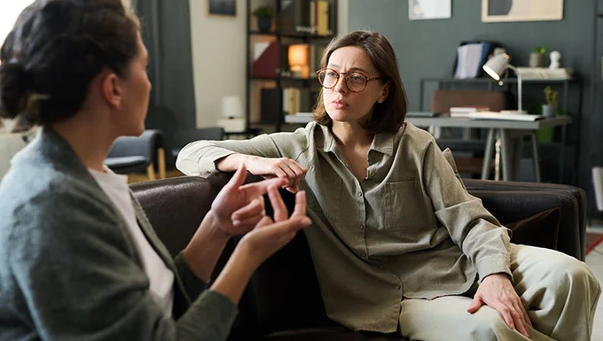 Photograph of two people talking