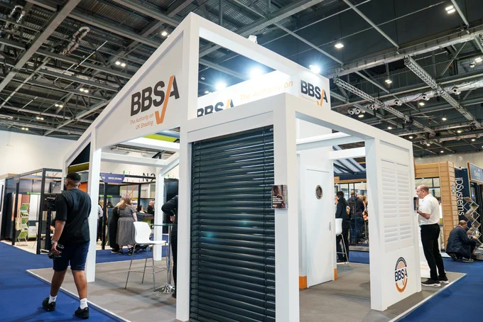 An exhibition booth for BBSA, the Authority on UK Shading, at a trade show. The booth features informative displays and invites interaction from attendees.