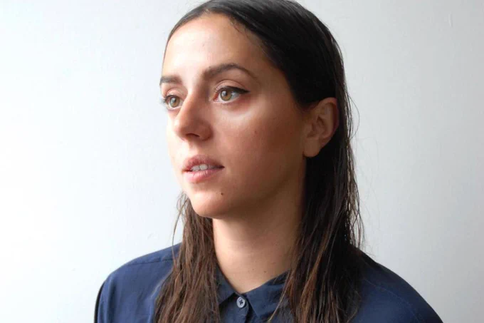 Nadia wearing a blue shirt and white background. 