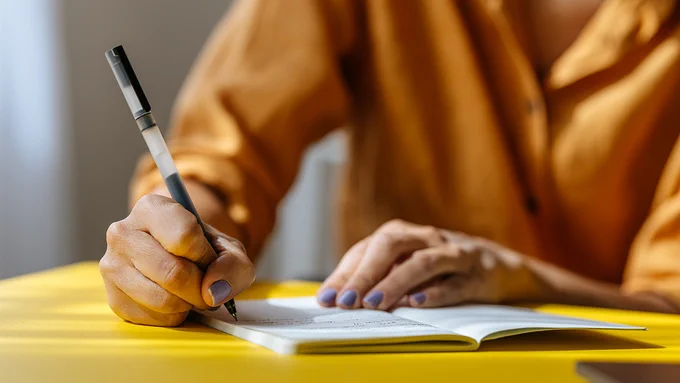 Person writing in a notebook.