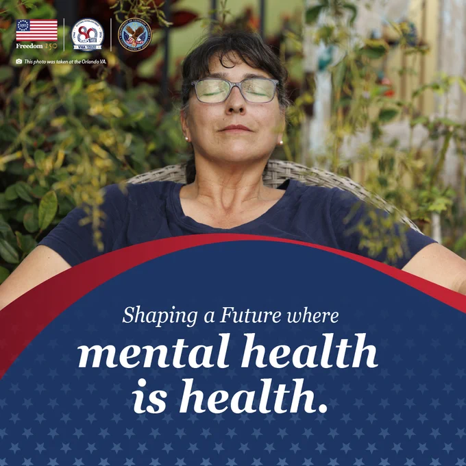 Person sitting outdoors behind a banner stating 'Shaping a Future where mental health is health.'