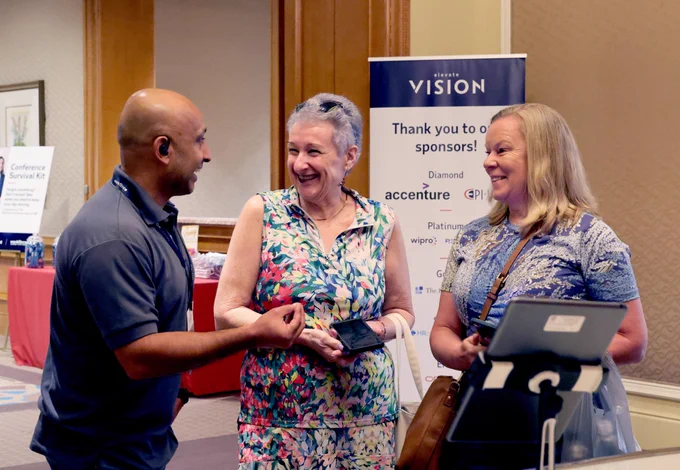Group of attendees interact, smiling