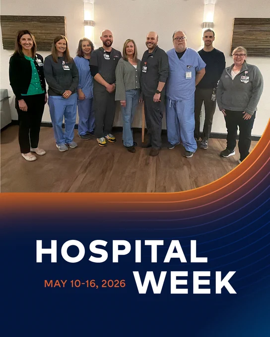 A group of hospital pharmacy team members stand together indoors, smiling and wearing scrubs and badges. Below the photo, a graphic reads “Hospital Week” with the dates May 10–16, 2026 on a blue and orange background. 