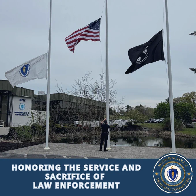 Three flags at half-mast outside the Massachusetts Police Training Committee building honoring law enforcement sacrifice.