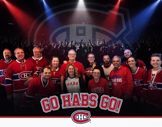 A group of employees wearing Montreal Canadiens hockey jerseys stand together in the foreground, posing for a team-style photo. Behind the group is a large Canadiens logo set against a dark arena scene with a cheering crowd silhouette and bright red, white, and blue spotlights shining down. At the bottom center of the image, bold text reads “GO HABS GO!” above the Canadiens logo. The overall scene combines a workplace team photo with a high-energy hockey game atmosphere