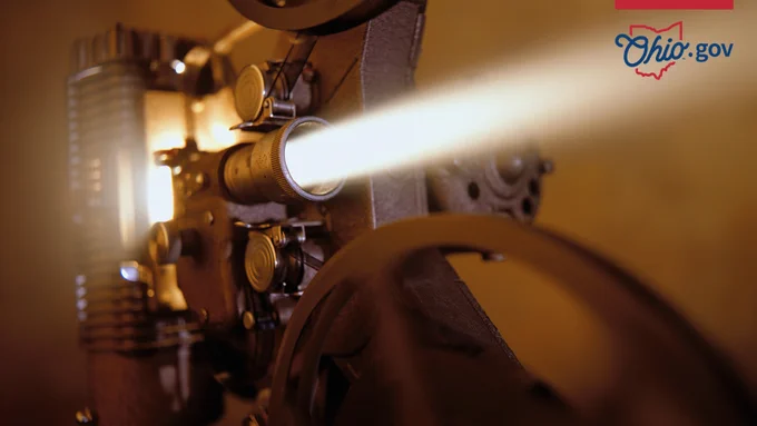 An old-fashioned movie projector is running a film.