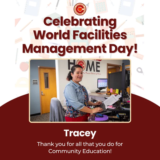 This image features a person standing at a desk in an office environment, smiling at the camera. The text above reads, "Celebrating World Facilities Management Day!" At the bottom, it says, "Tracey - Thank you for all that you do for Community Education!" Various office items are visible in the background.