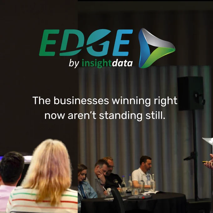 Audience members at a business conference with a tagline promoting proactive business strategies. The scene includes attentive individuals and a speaker.