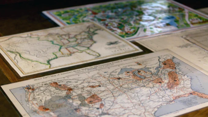 Pictured are four maps sitting on a table in Special Collections.