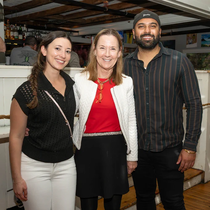Three attendees pose together inside a restaurant during a Stony Brook GOLD alumni networking event.