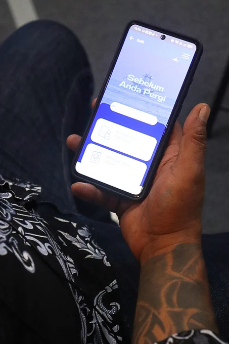 A person holds a mobile phone with the IKAN app on display. Credit: Indonesia Ocean Justice Initiative
