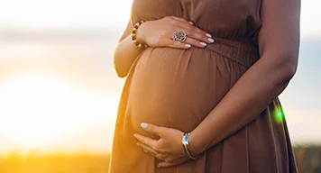 Image of woman holding pregnant stomach
