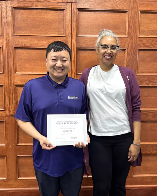 Kirmser Research Award recipient Lei Zhong poses with his certificate alongside Associate Dean Tara Coleman.