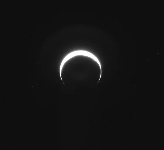 A brightly glowing crescent against the darkness of space.