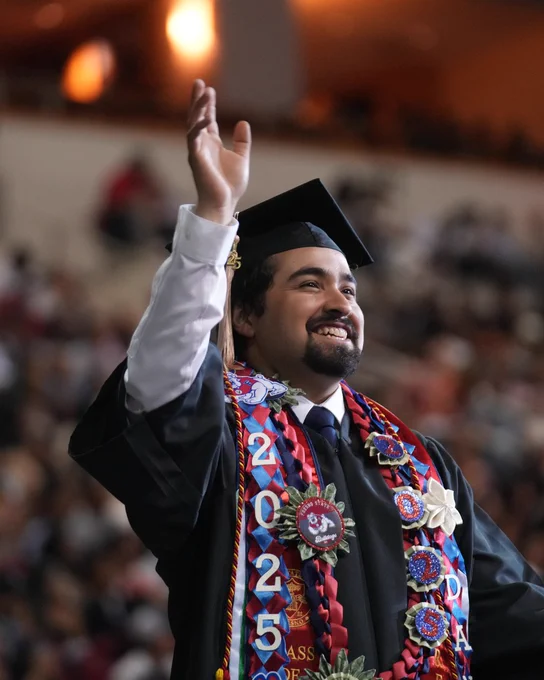Student smiling and waving.