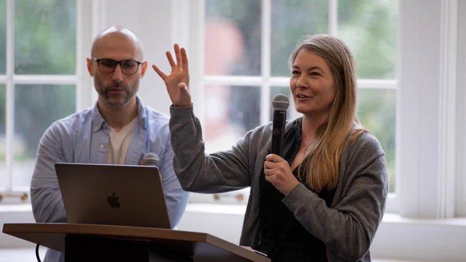 Two people speaking at a podium.