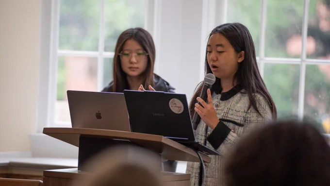 Two people speaking at a podium.