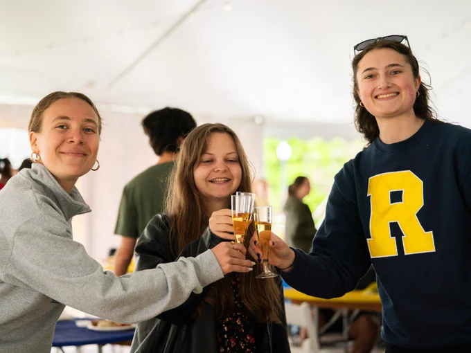 Three students raising a glass for a toast. 