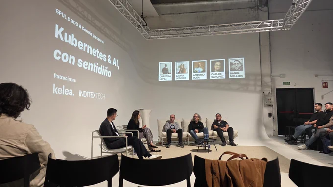 A panel discussion on Kubernetes and AI features speakers seated on a stage, with an audience visible in the background.