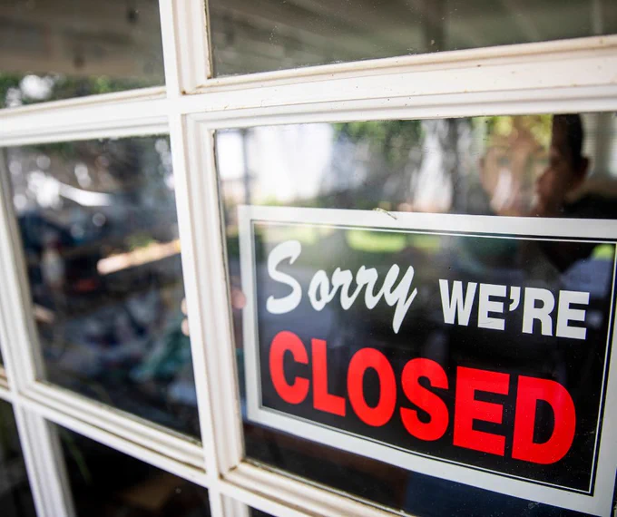  A sign with the text "Sorry we're closed" in a glass shop window.