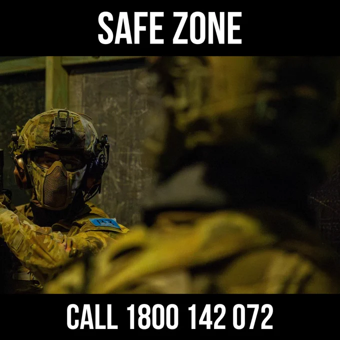 Camouflaged soldier with helmet and face mask. Text: \"SAFE ZONE\" at the top, \"CALL 1800 142 072\" at the bottom.
