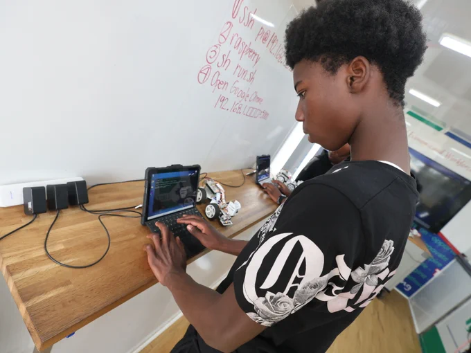 Student setting up programming for robotic car exercise.