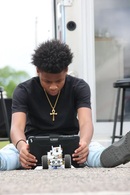 Student programs with code to move a robotic car.