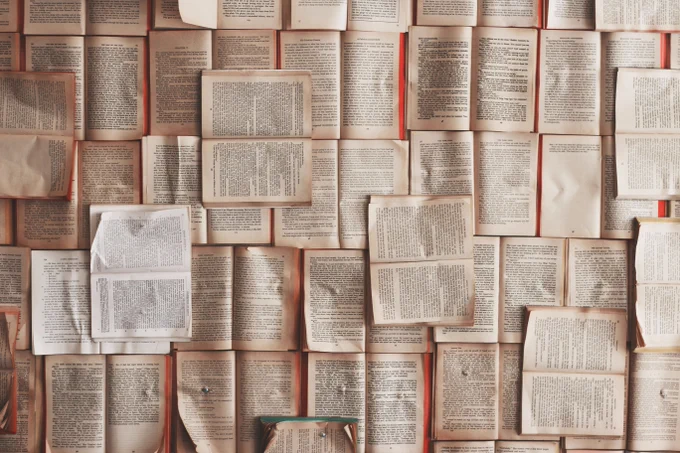 Opened books overlap across each other, filling the image.