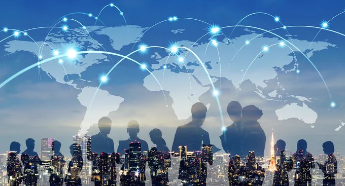 Silhouettes of business people over a city skyline with a world map and glowing network connections symbolizing global communication.