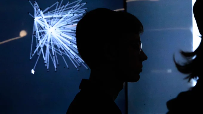 Image of a person's profile in a dimly lit room.