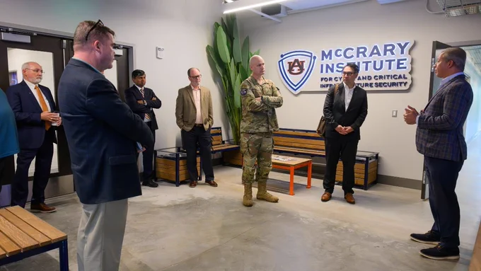 Image of eight people standing in a room talking.