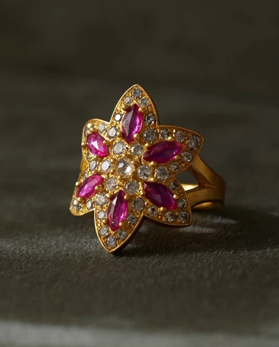 A luxurious gold ring with a floral design featuring rubies and diamonds. The setting provides an opulent and sophisticated look.