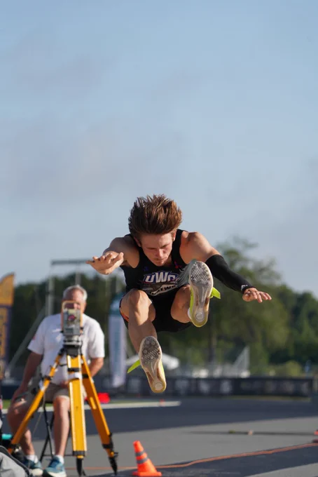 A male athlete jumping triple jump