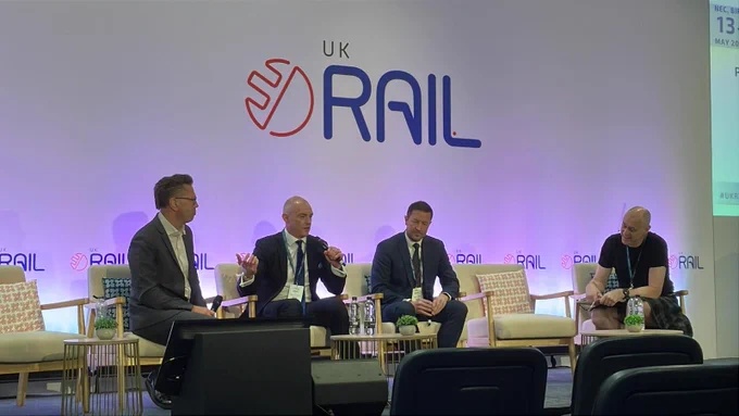 Photo of Mike talking on a panel discussion at Rail UK 2026.