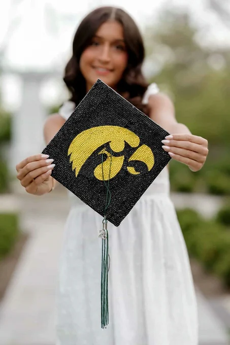 Future Hawkeye holding out an Iowa grad cap.