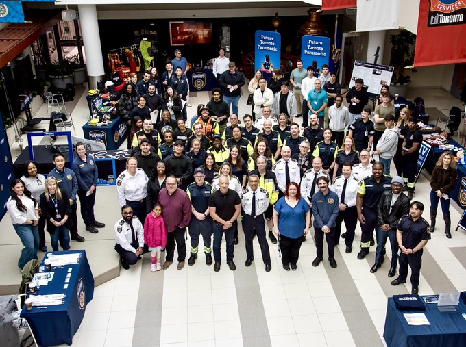 Group of paramedic students and staff standing in the atrium at headquarters.