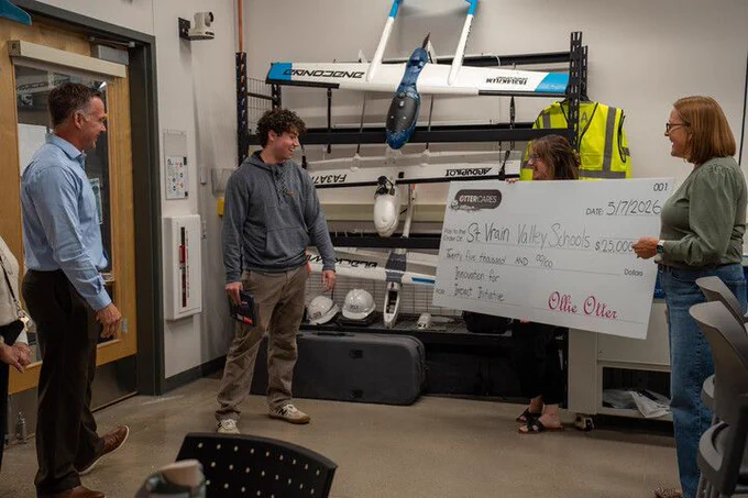 Otter Cares presents large $25K check to student labeled St. Vrain Valley Schools