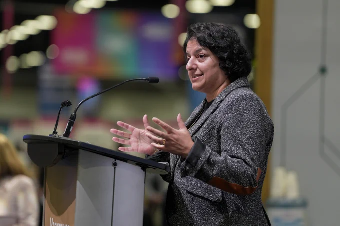 PacifiCan’s President Naina Sloan speaks from a podium on stage to an audience at the BC Pavilion at Web Summit Vancouver 2026.