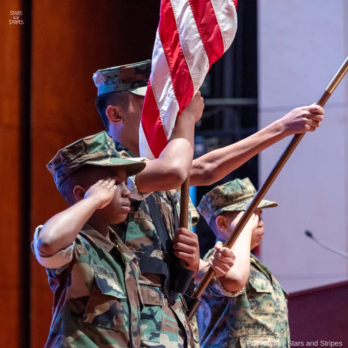 Three children representing the Young marines present colors, in uniform. (Eric Kayne/Stars and Stripes)
