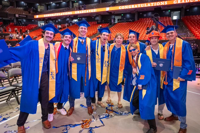 Group of Boise State graduates smiling together after receiving their diplomas at the Spring 2026 commencement ceremony. 
