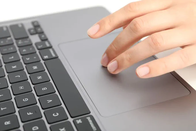 MacBook Pro trackpad being used for clicking and gestures, illustrating pressure‑based trackpad behavior affected by battery swelling issues.