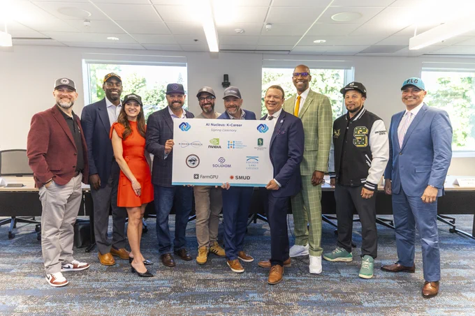A group of individuals wearing business attire and caps stands in a conference room, holding a large sign with various company logos.