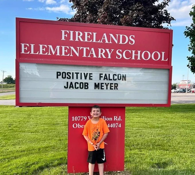 Student in front of sign 