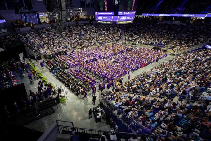 Graduates fill the floor of the Atlantic Union Bank Center. Surrounding them are their families and friends in the stands.