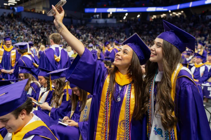 A student holds up their phone to take a picture before the commencement ceremony begins.