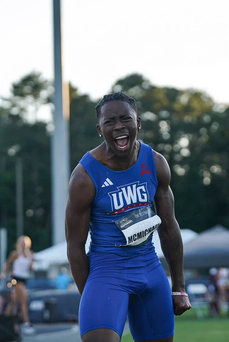 track athlete in blue celebrating at a track meet