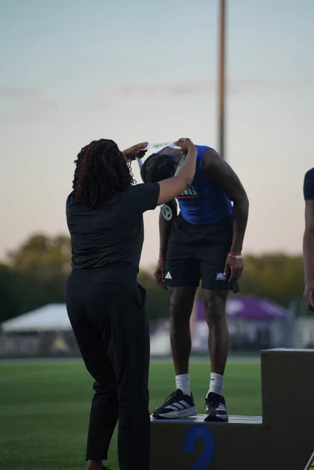a person putting a medal on someone’s neck on a podium